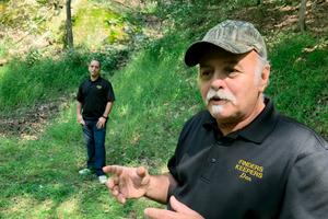Dennis Parada, right, and his son Kem Parada stand at the site of the FBI's dig for Civil War-era gold in Dents Run, Pennsylvania.