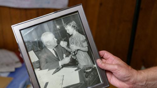 A frame is held showing a picture of Alice “Candy” Loughney as a young girl with her father, Joseph M. Barr.